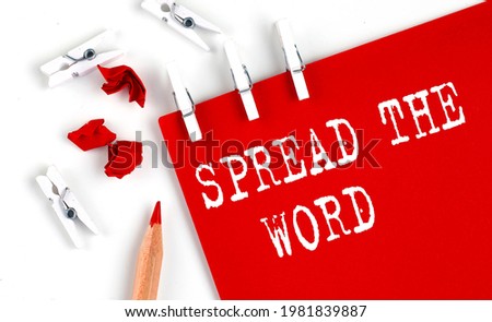 SPREAD THE WORD text on red paper with office tools on the white background