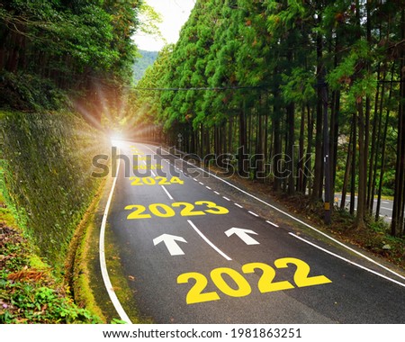 Future ahead from 2022 to 2030 with arrow on highway road and white marking lines in the forest. Business recovery concept and challenge to success idea Royalty-Free Stock Photo #1981863251