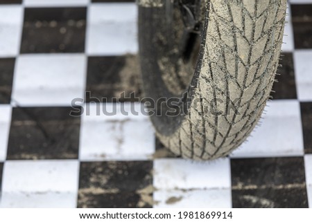 The wheel of the motorcycle is sporty for cross and motorcycle freestyle, racing against the background of white and black background cells. The concept of professional motorsport. Copyspace