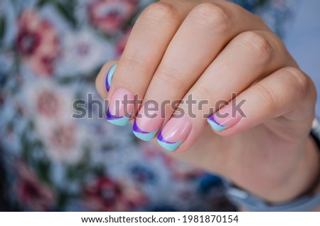 The hand of a young woman with a decorative French manicure. Royalty-Free Stock Photo #1981870154