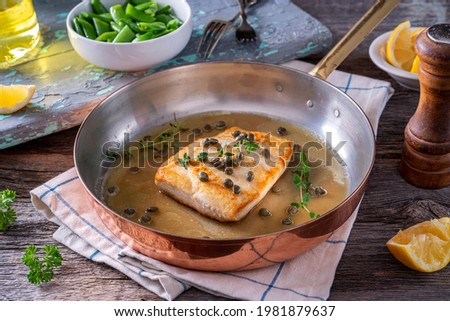 Delicious pan seared halibut with lemon brown butter and capers. Royalty-Free Stock Photo #1981879637