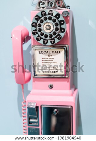 old retro pink wall phone on blue background Royalty-Free Stock Photo #1981904540