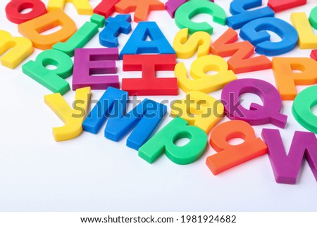 Many colorful magnetic letters on white background