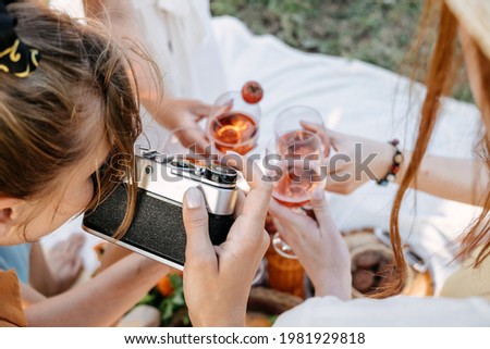 Social Media Content Ideas, Content creator for brands, food blog, summer picnic. Young woman food blogger, content creator with professional camera taking food photo of croissant in picnic on nature