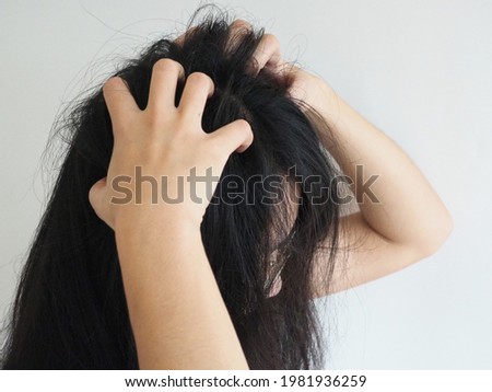 dandruff or lice in her hair woman and scratching her head for healthcare concept. 
