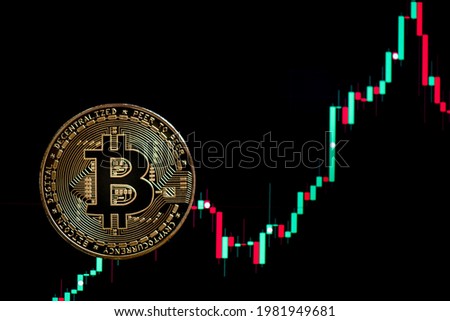 Bitcoin gold coin and defocused black chart background. Virtual cryptocurrency concept.