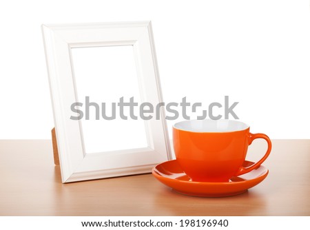 Photo frame and coffee cup on wooden table. Isolated on white background