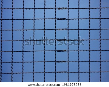 A wire net on a blue background.