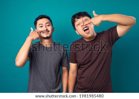 Man laughing and cheer with his friend against color background