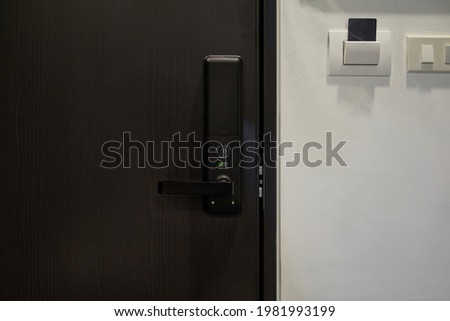 Digital door lock on modern black wooden door for protection and safety for home. 
