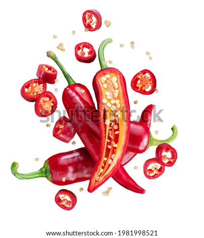 Fresh red chilli peppers and cross sections of chilli pepper with seeds floating in the air. File contains clipping paths. Royalty-Free Stock Photo #1981998521