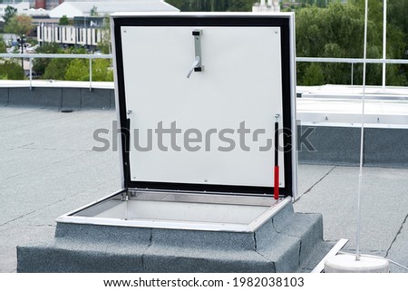 hatch on flat roof covered with bitumen membrane. Royalty-Free Stock Photo #1982038103