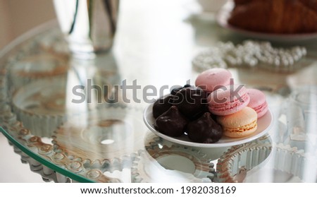 Macaroons on a glass table. Sweets for breakfast. Sunny photo. Romantic breakfast concept