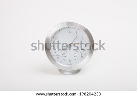 Clock made of silver polished aluminum steel which indicate eight hours 5 minutes.
