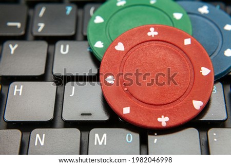 Image shows casino gambling chips on computer showing the concept of online card games