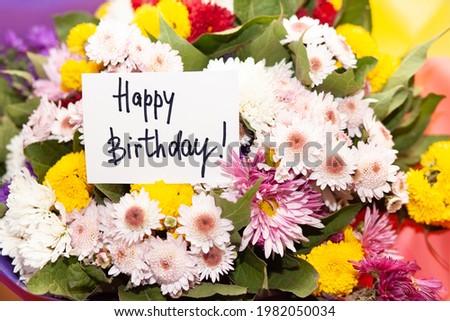 Happy birthday card with greeting words and colorful bouquet of mixed flowers