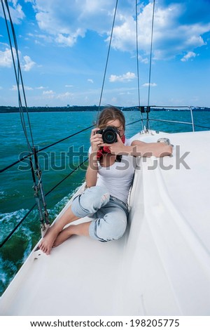 Girl with a camera on a snow-white yacht in the sea pictures of landscapes