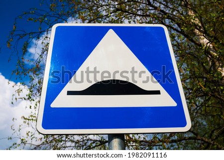 road sign speed bump. blue square with white triangle and black obstacle. High quality photo
