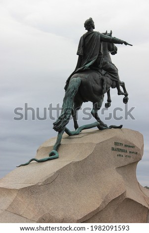 Back view of the Bronze Horseman statue of Peter the Great situated in the Senate Square in St. Petersburg in Russia in daylight, the statue is in the foreground, blue cloudy sky is in the background Royalty-Free Stock Photo #1982091593