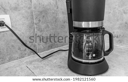 Black coffee maker from Mexico on cream background in clean kitchen Black and white picture. Royalty-Free Stock Photo #1982121560