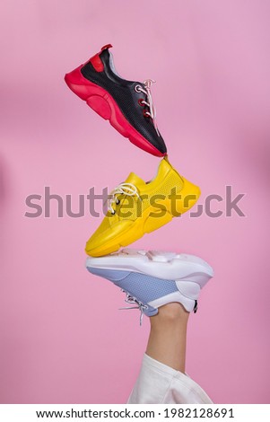 Summer women's shoes. Levitation. Flying shoes, sneakers. The shoes stand on top of each other. Colorful summer shoes. Royalty-Free Stock Photo #1982128691