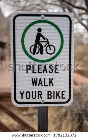 Please Walk Your Bike Sign Along Trail In Zion National Park