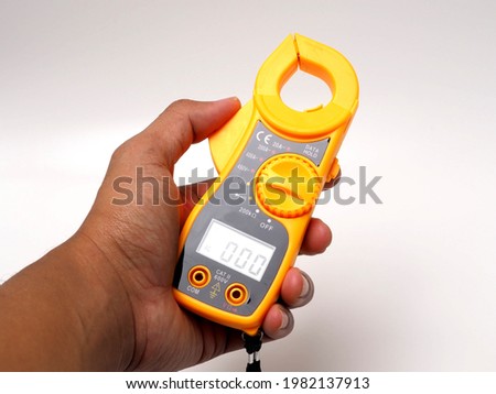 Picture of yellow digital clamp meter that using for measuring electrical current, voltage and resistance. Shoot on white isolated background.