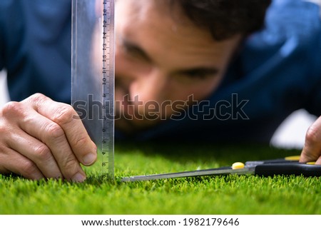 Compulsive Obsessive Disorder. Perfectionist Measuring Garden Grass Royalty-Free Stock Photo #1982179646