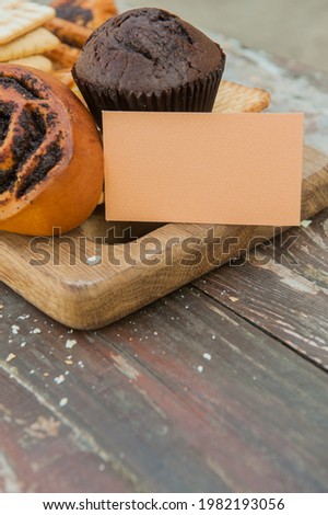 Assorted pasrties set with empty business card on a wooden old style rustic backdrop