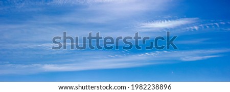 Panorama of blue sky with white clouds floating in the sky on a clear sunny warm day, summer sky landscape with blurred abstract clouds.