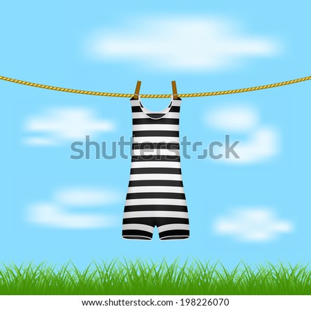 Striped retro swimsuit hanging on rope 