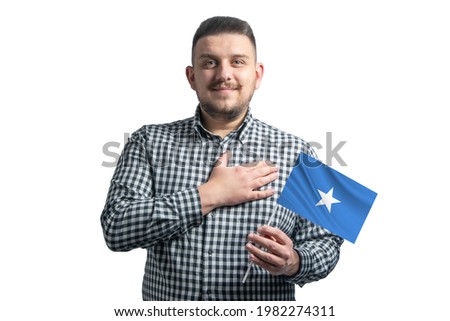 White guy holding a flag of Somalia and holds his hand on his heart isolated on a white background With love to Somalia.