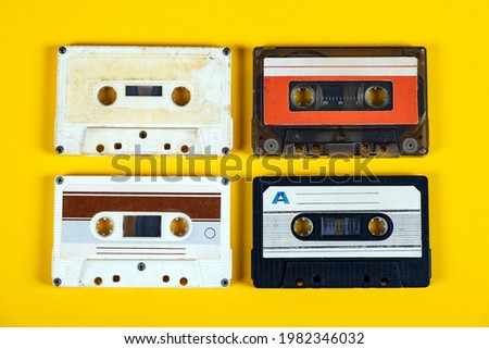 Four Old Audio Cassettes on the Yellow Paper Background closeup