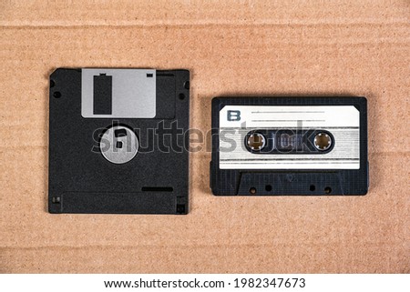 Floppy Disk Drive and Old Audio Cassette on the Cardboard Background closeup