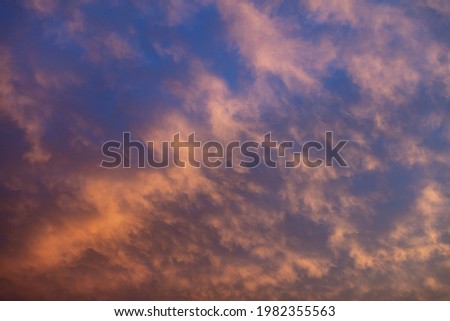 Coloring the sky concept. Sunbeams through heavy clouds paint the heaven with blue black grey orange yellow colors background, space. Dramatic cloudscape idyllic abstract scene.