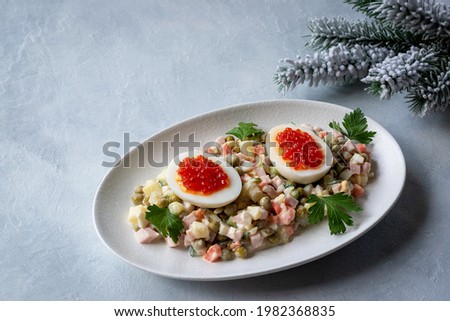 Olivier salad is a traditional Russian dish seasoned with mayonnaise, an essential attribute of the festive New Year's table and Christmas. Copy space. Royalty-Free Stock Photo #1982368835
