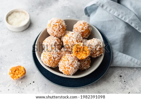apricot coconut bliss balls in blue bowl on gray background. raw vegan dessert without sugar. close-up Royalty-Free Stock Photo #1982391098