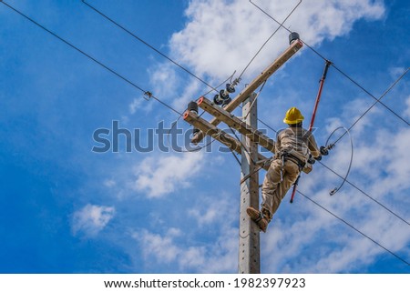 The power lineman use clamp stick (insulated tool) to closing a transformer on energized high-voltage electric power lines. The power lineman must be trained because it is a risky job Royalty-Free Stock Photo #1982397923