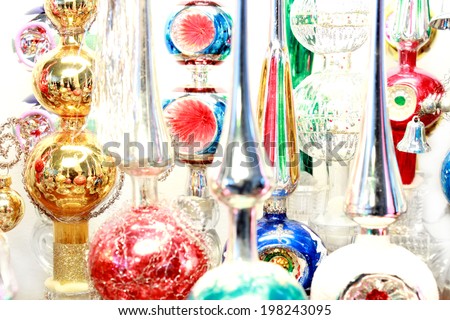 Many antique, glass Christmas tree topper ornaments displayed over a white background.