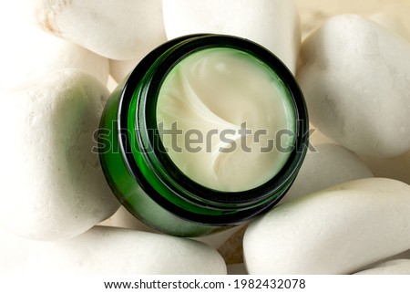 Open skin care packaging with white cream on the natural stones.Natural background.Concept of the zero waste,organic cosmetic.