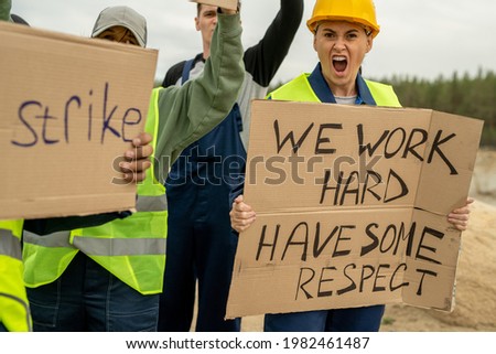 Crowd of dissatisfied builders standing for their rights on strike
