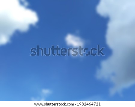 Picture blur of big and small clouds lurking in the bright blue sky.