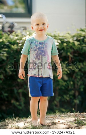 Barefoot boy stands on the sand Royalty-Free Stock Photo #1982474321