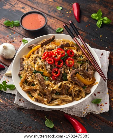 Stir fry Beef Chow Fun with rice noodles, bean sprouts, spring onions and chili Royalty-Free Stock Photo #1982475383