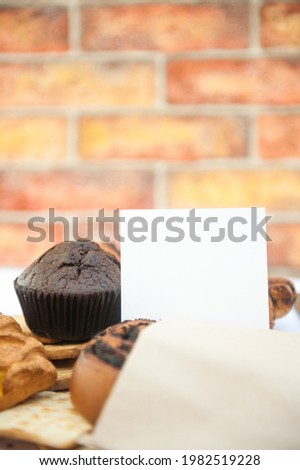Bright pastries photo mockup with white empty list template and muffin in city cafe