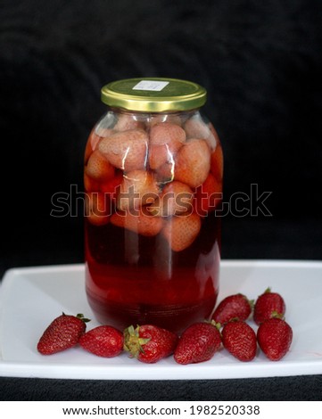 Jar with Strawberry Compote, on a black background