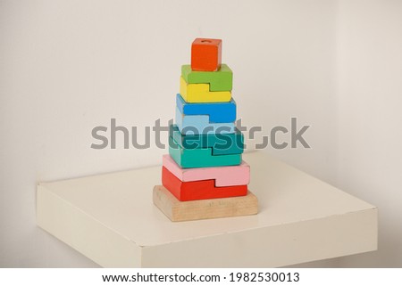 Colorful wooden children's toy pyramid on a white background. Eco-friendly toy, no plastic. A toy for babies and toddlers. Toys made of natural wood. The colors of the rainbow.