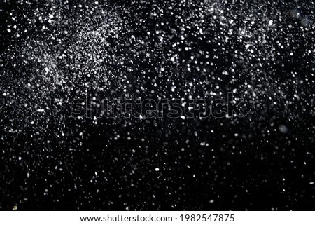 Many snowflakes in blur on black background. Snowfall layer for winter photography. Royalty-Free Stock Photo #1982547875