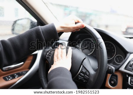 Man hand presses horn on steering wheel of car