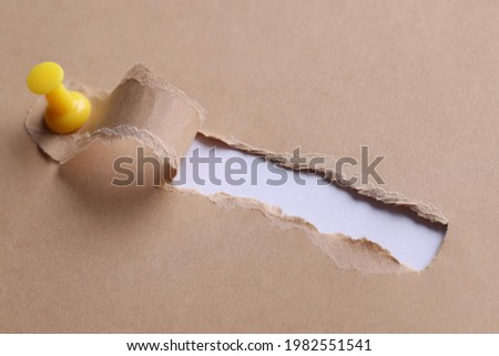 Inscription search in hole on white paper with ragged edges
